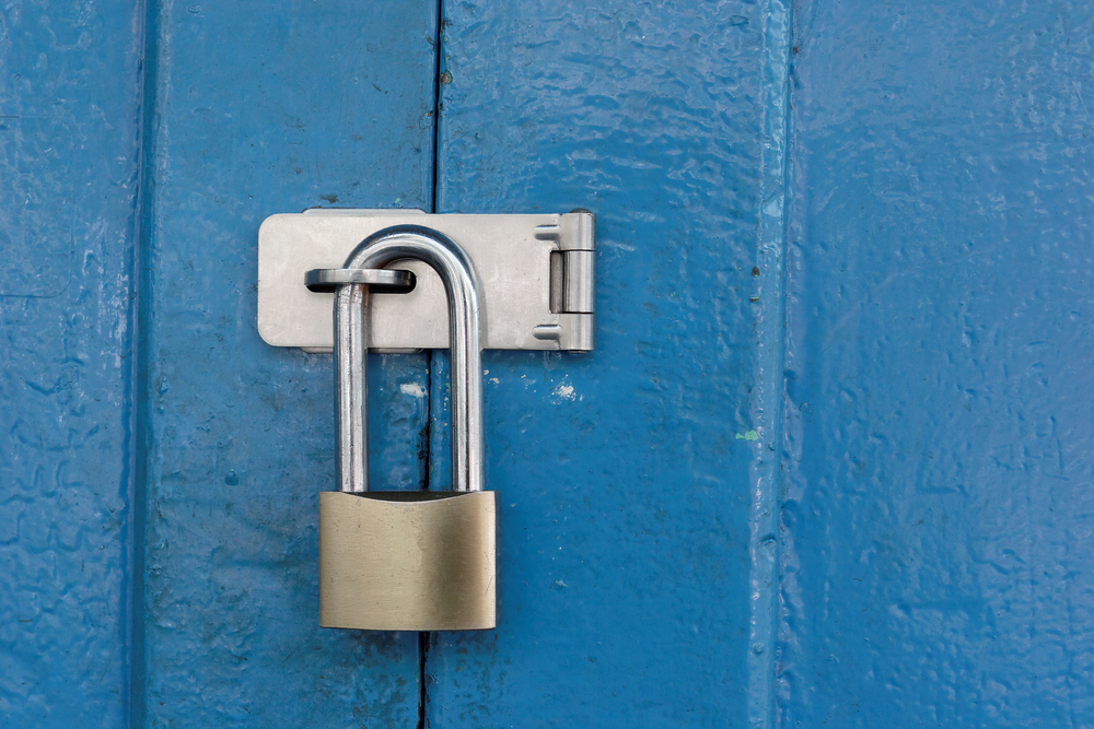 Blue door locked with a padlock