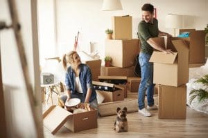 young couple in new apartment moving into home with boxes